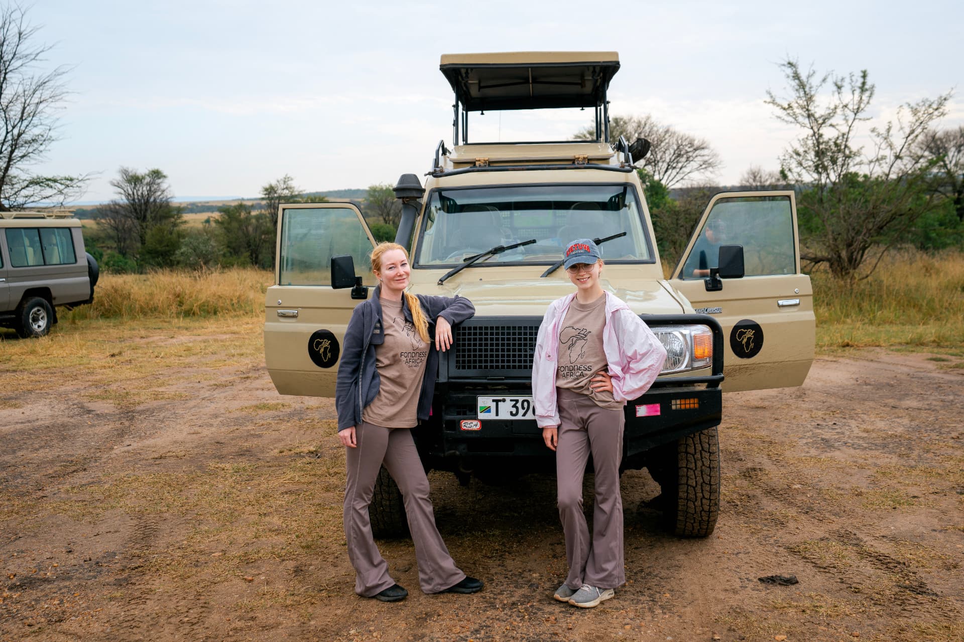 Guests beside their Fondness safari vehicle